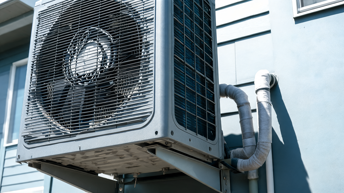 Gros plan sur le ventilateur et la grille d'une unité extérieure de pompe à chaleur réversible