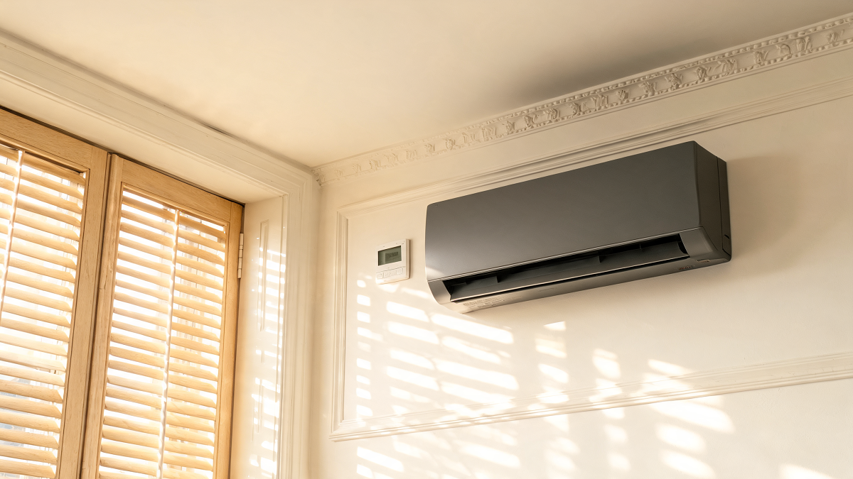 Thermostat mural et unité de climatisation réversible dans un séjour ensoleillé