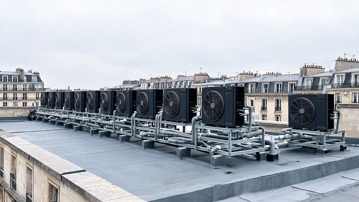 Unités extérieures d'une pompe à chaleur collective air/eau en toiture-terrasse d'un immeuble résidentiel