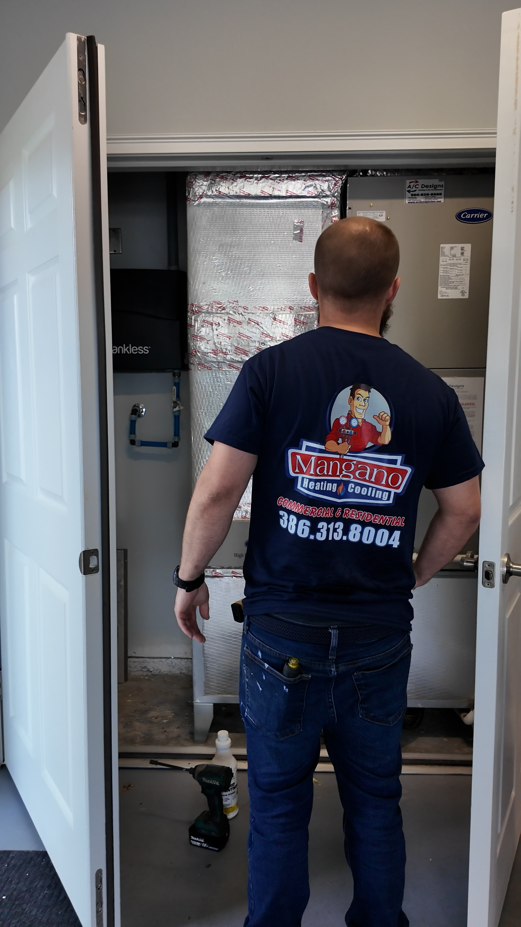 Mangano HVAC technician installing a new indoor air handler in a Flagler County home