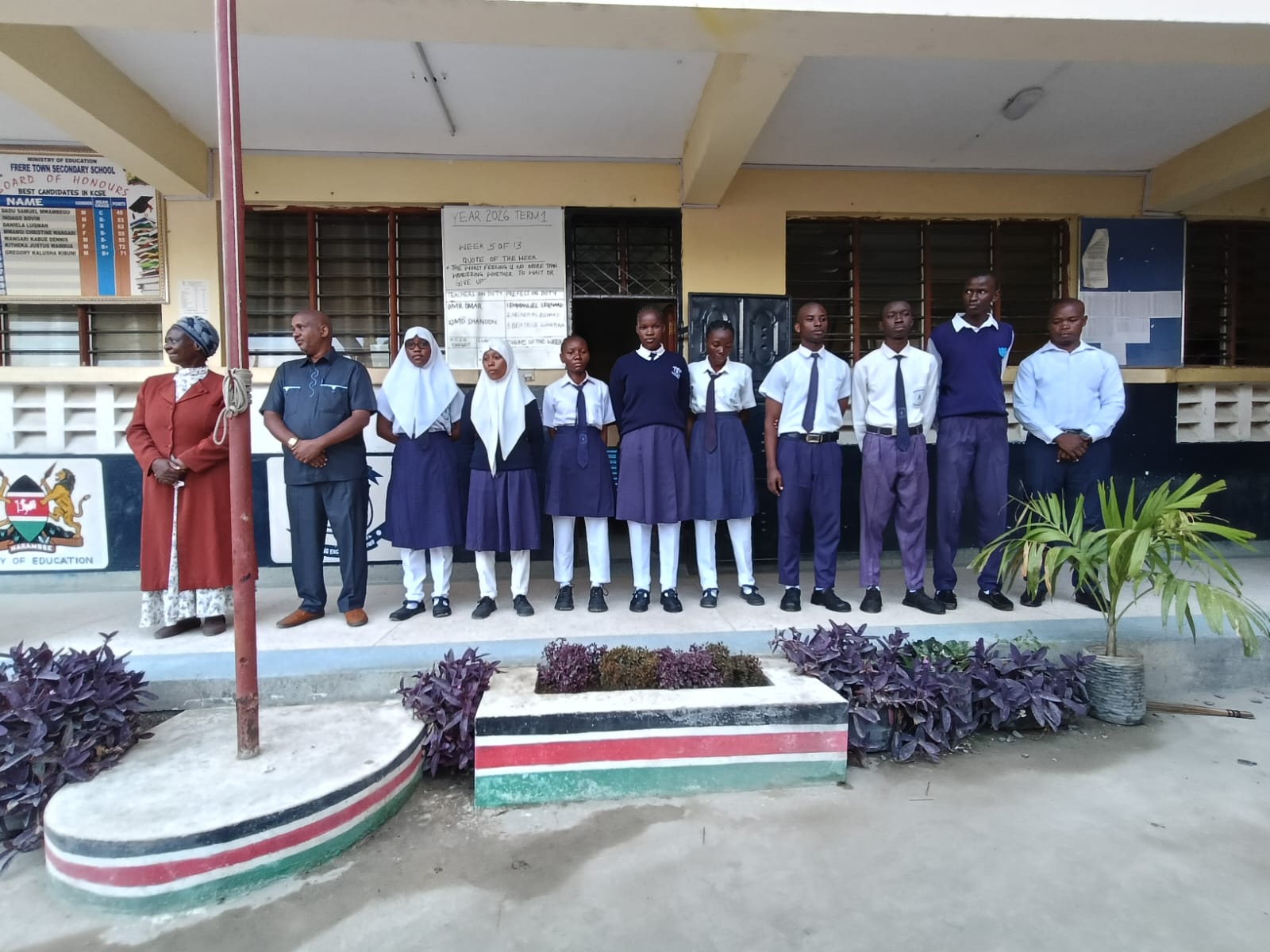 Kenyan secondary school students in uniform at Frere Town Secondary School standing in front of the school building