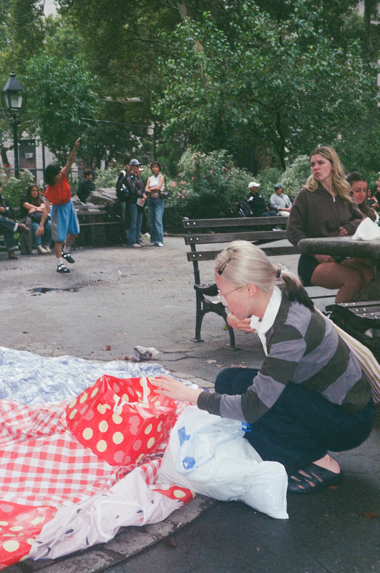 Person sitting with red textile in Columbus Park