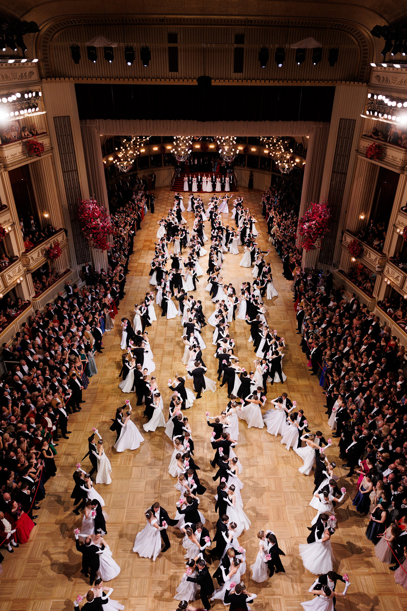 Salón de baile de la ópera lleno de parejas de gala.