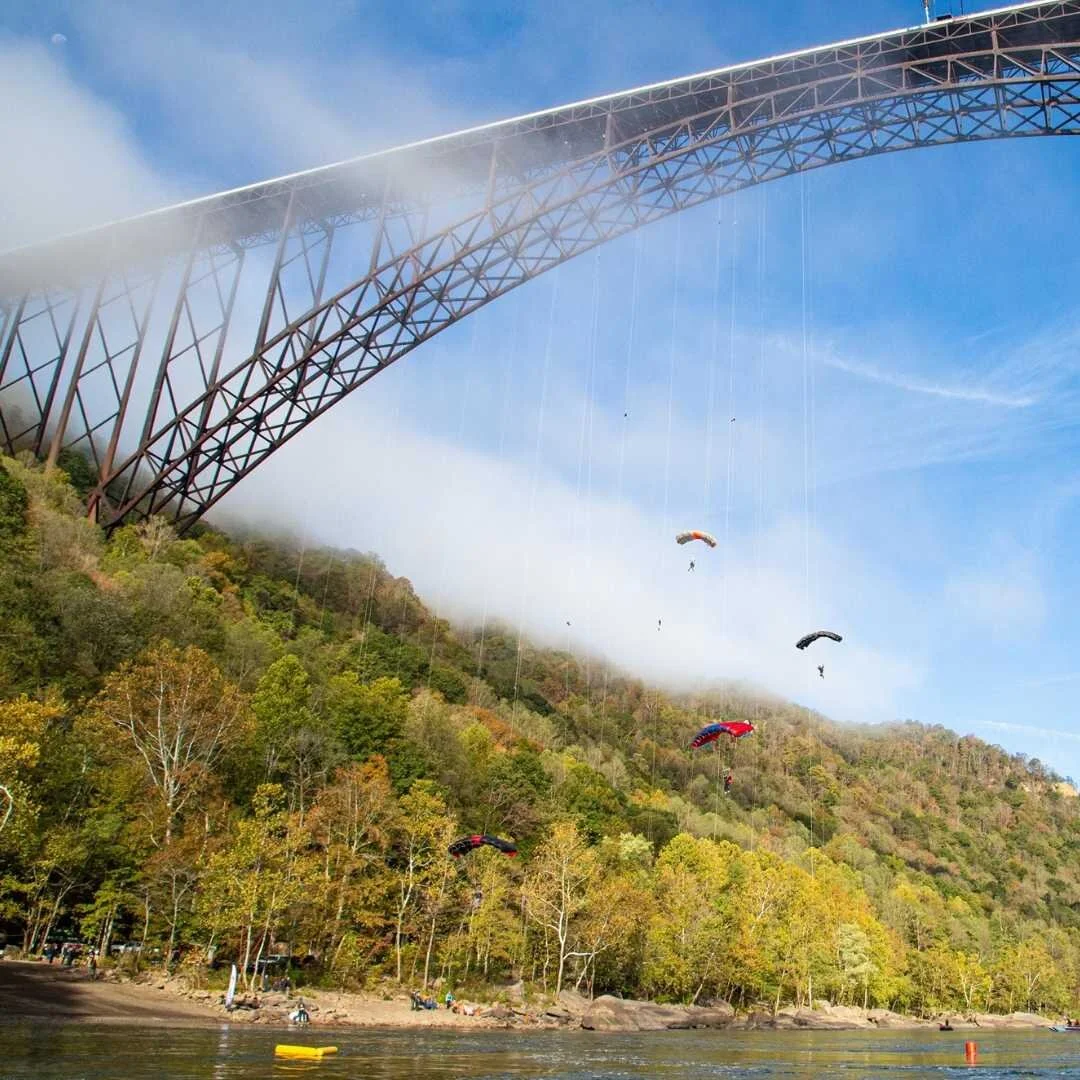 Paracaidistas saltando desde un puente sobre un cañón.