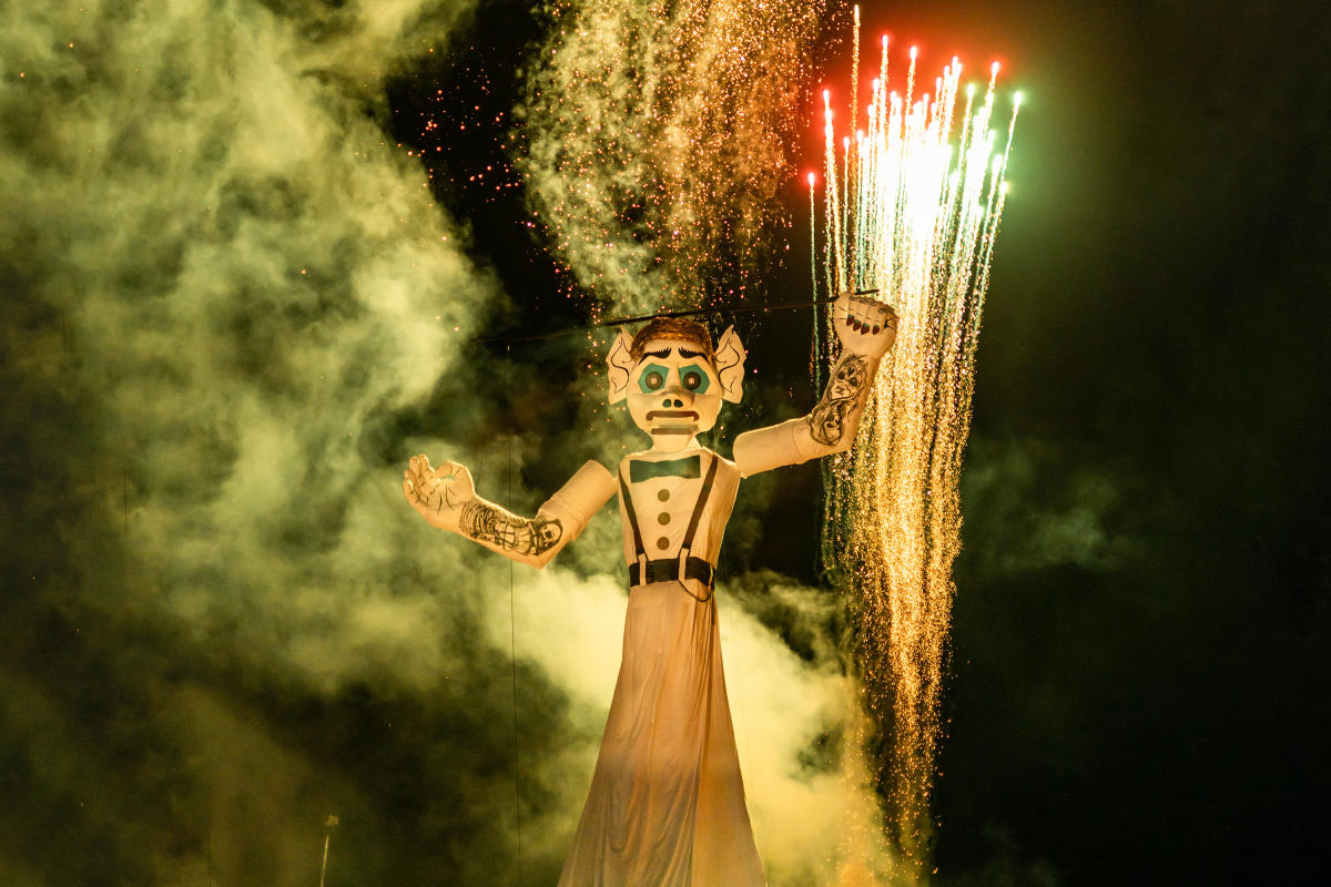 Títere gigante ardiendo bajo fuegos artificiales.