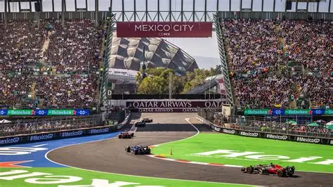 Coches de F1 pasando frente a gradas repletas.