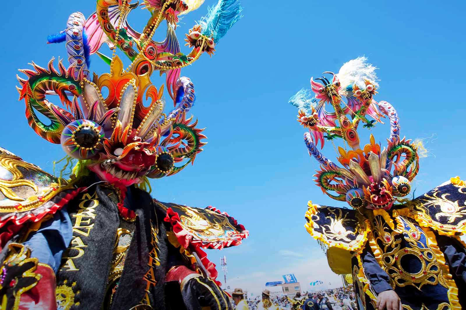 Bailarines con trajes dorados y máscaras.