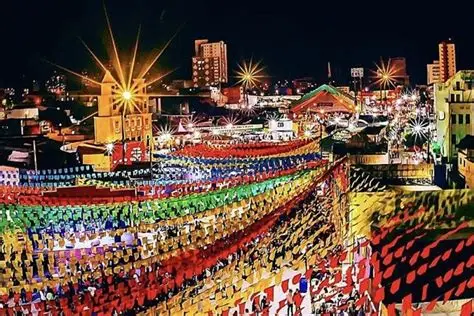 Multitud bailando forró bajo banderines de colores.