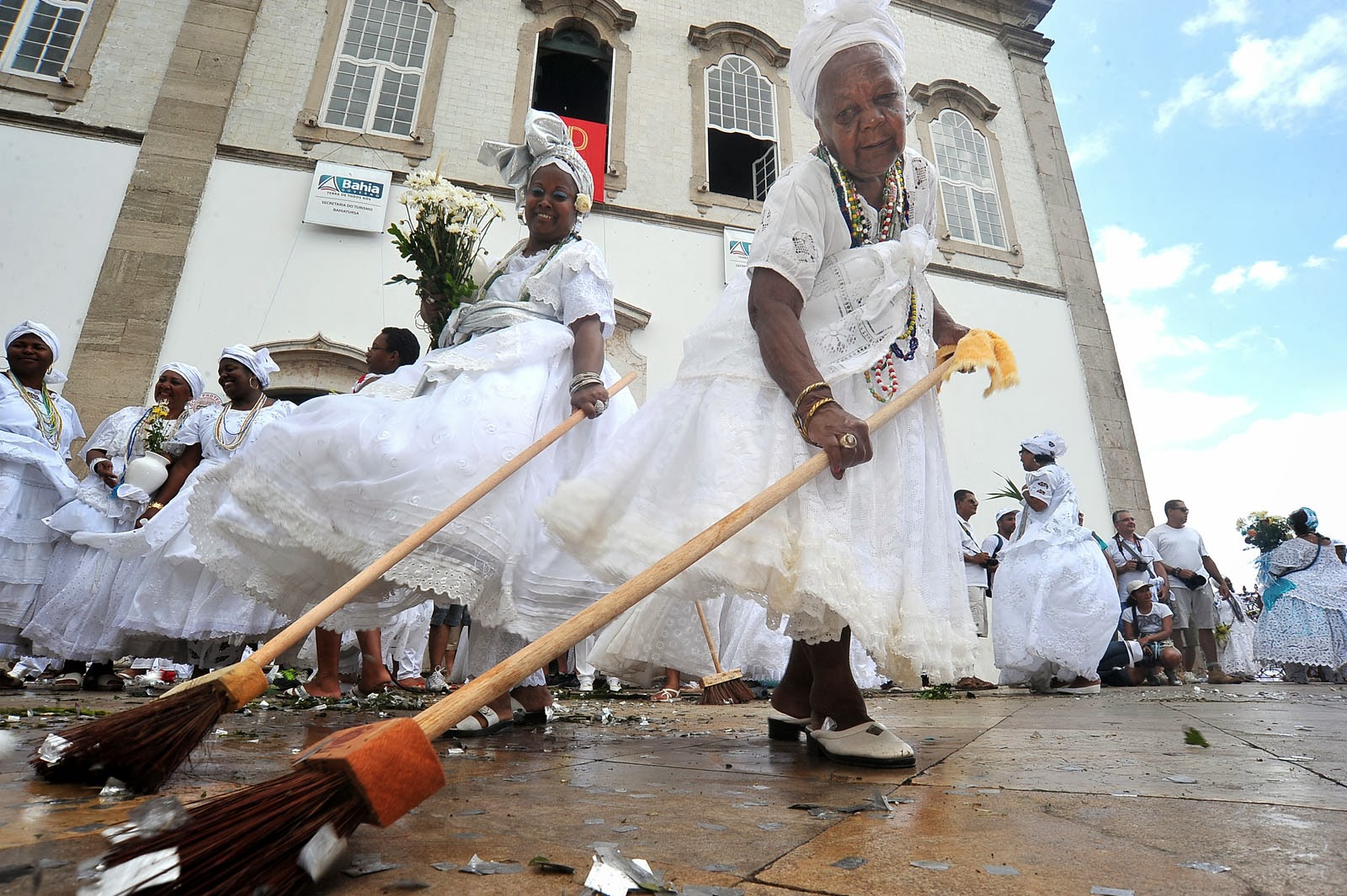 Baianas vestidas de blanco con flores.