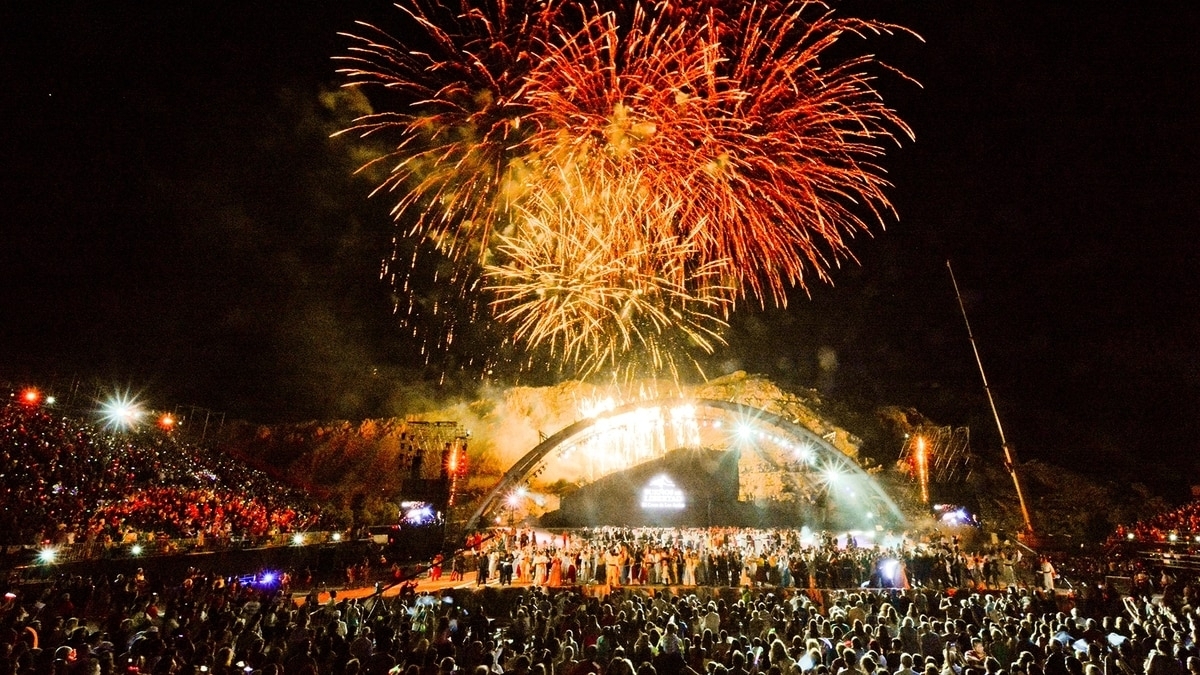 Show de luces y artistas en un escenario gigante.