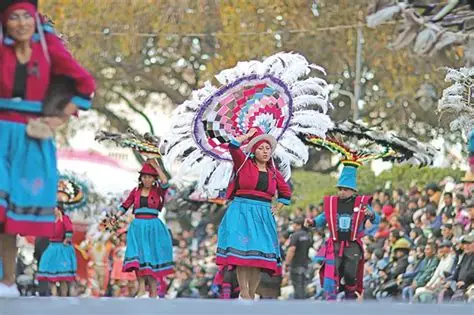 Bailarines con trajes de lentejuelas en una calle colonial.