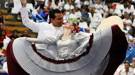 Pareja bailando marinera con pañuelos blancos.