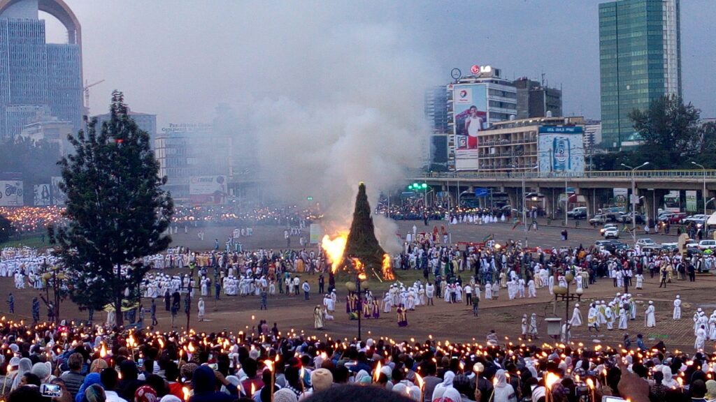 Hoguera gigante rodeada de miles de personas con velas.