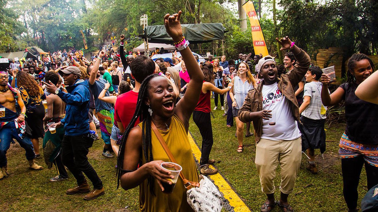 Gente bailando bajo la lluvia tropical junto al Nilo.