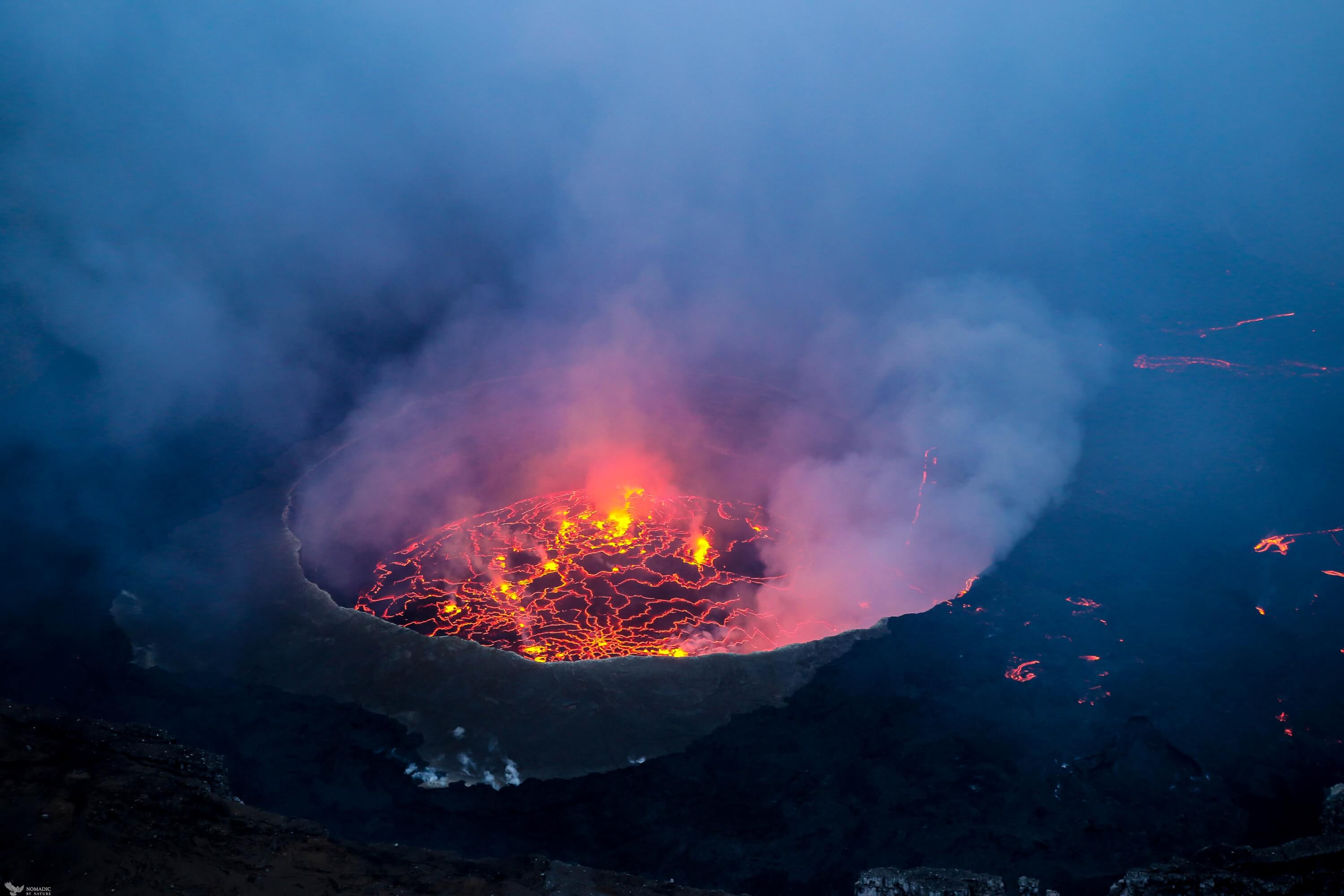Brillo rojo del lago de lava de noche.