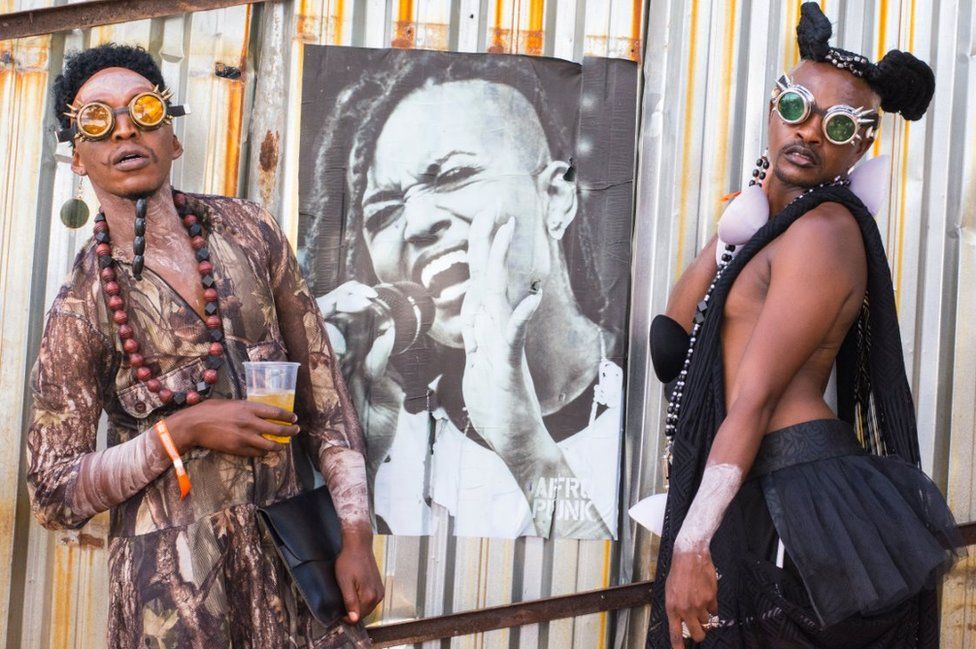 Asistentes con estilos de moda futurista africana.