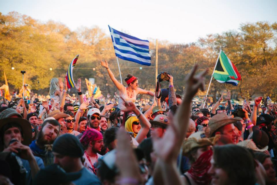 Escenario de música rodeado de matorrales y polvo.