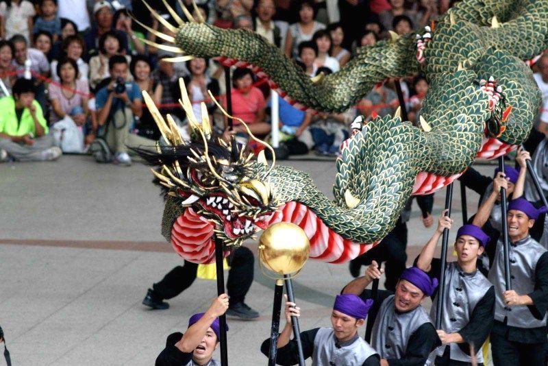 Danza del dragón chino frente a un templo japonés.