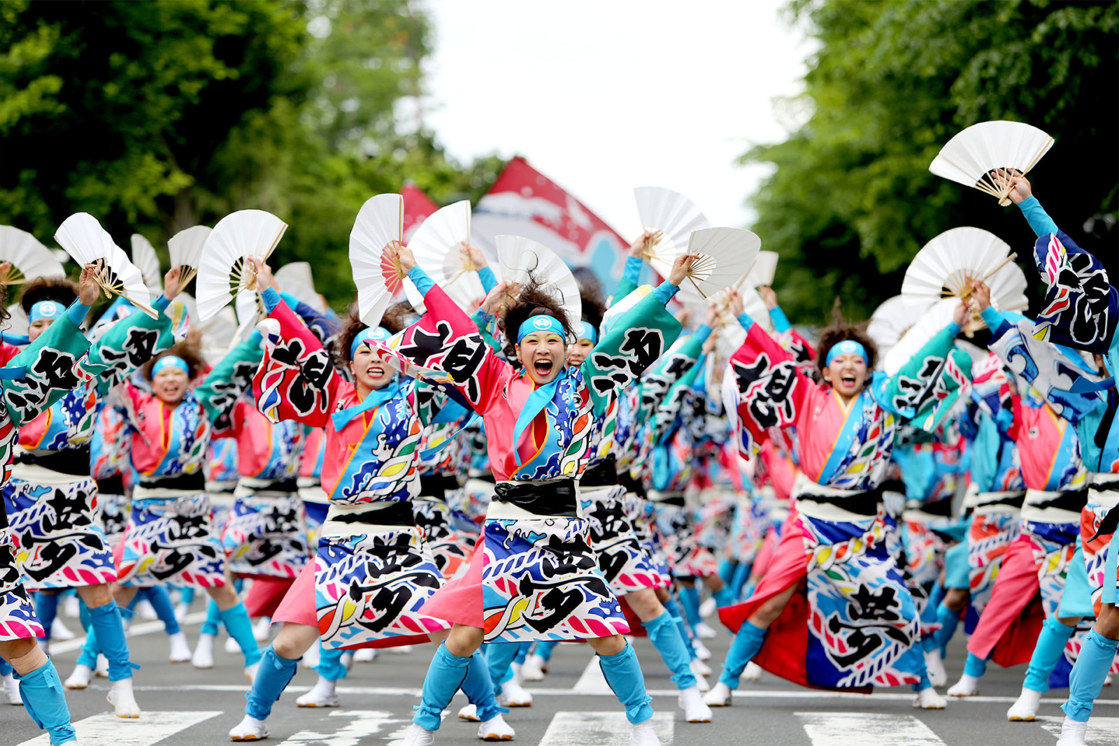 Bailarines con trajes coloridos y banderas gigantes.