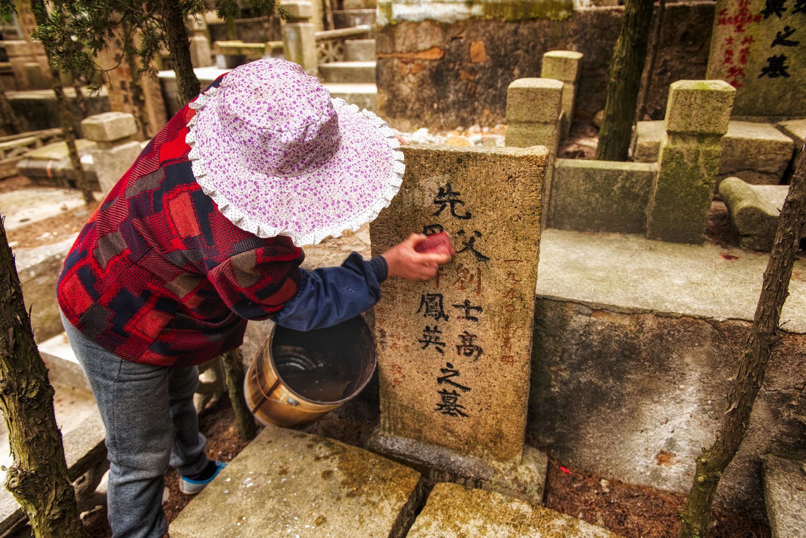 Gente quemando incienso en un cementerio tradicional.
