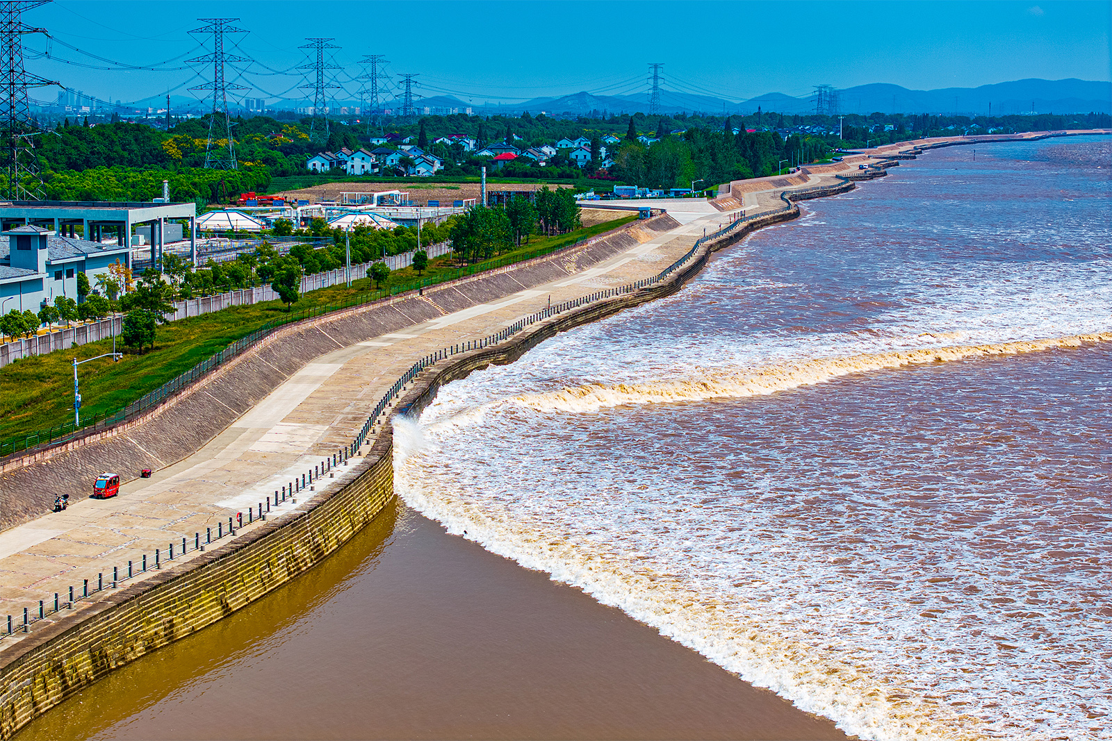 Ola gigante de río rompiendo frente a espectadores.