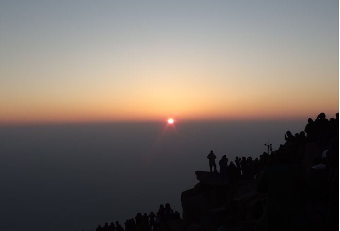 Sol saliendo entre las rocas de la cima sagrada.
