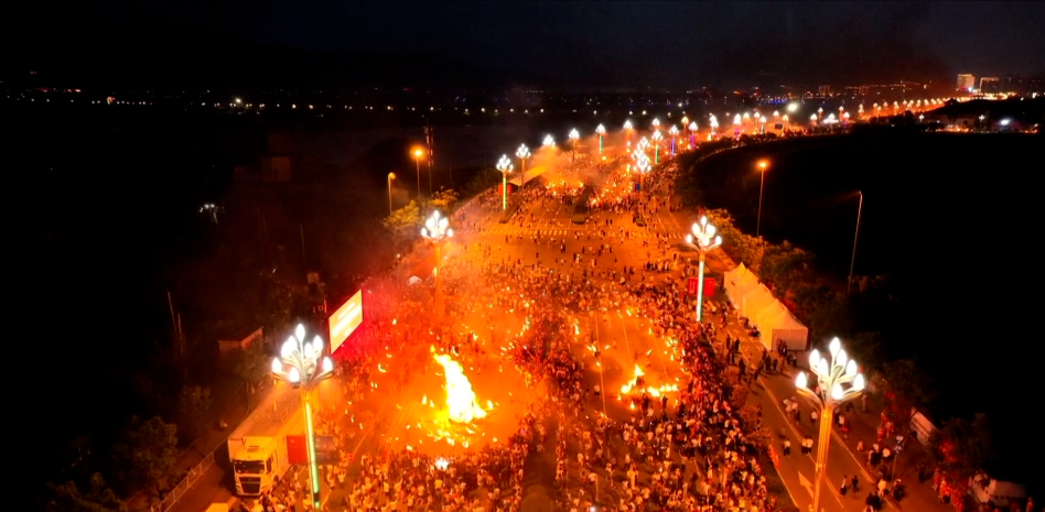 Miles de antorchas encendidas en un campo de noche.