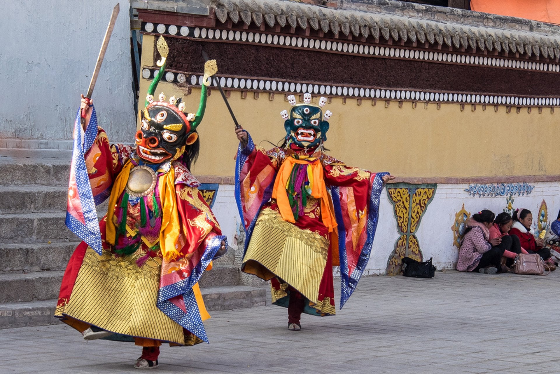 Monjes tibetanos bailando con máscaras en un templo.