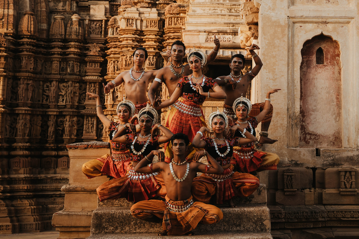 Bailarina de Odissi frente a un templo tallado.