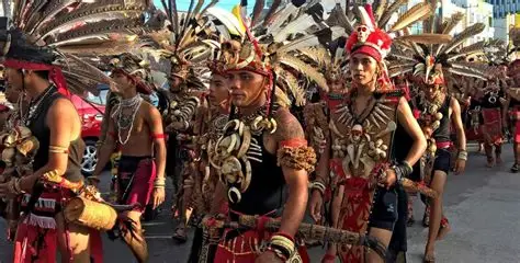 Jóvenes Dayak con trajes de plumas y tatuajes.
