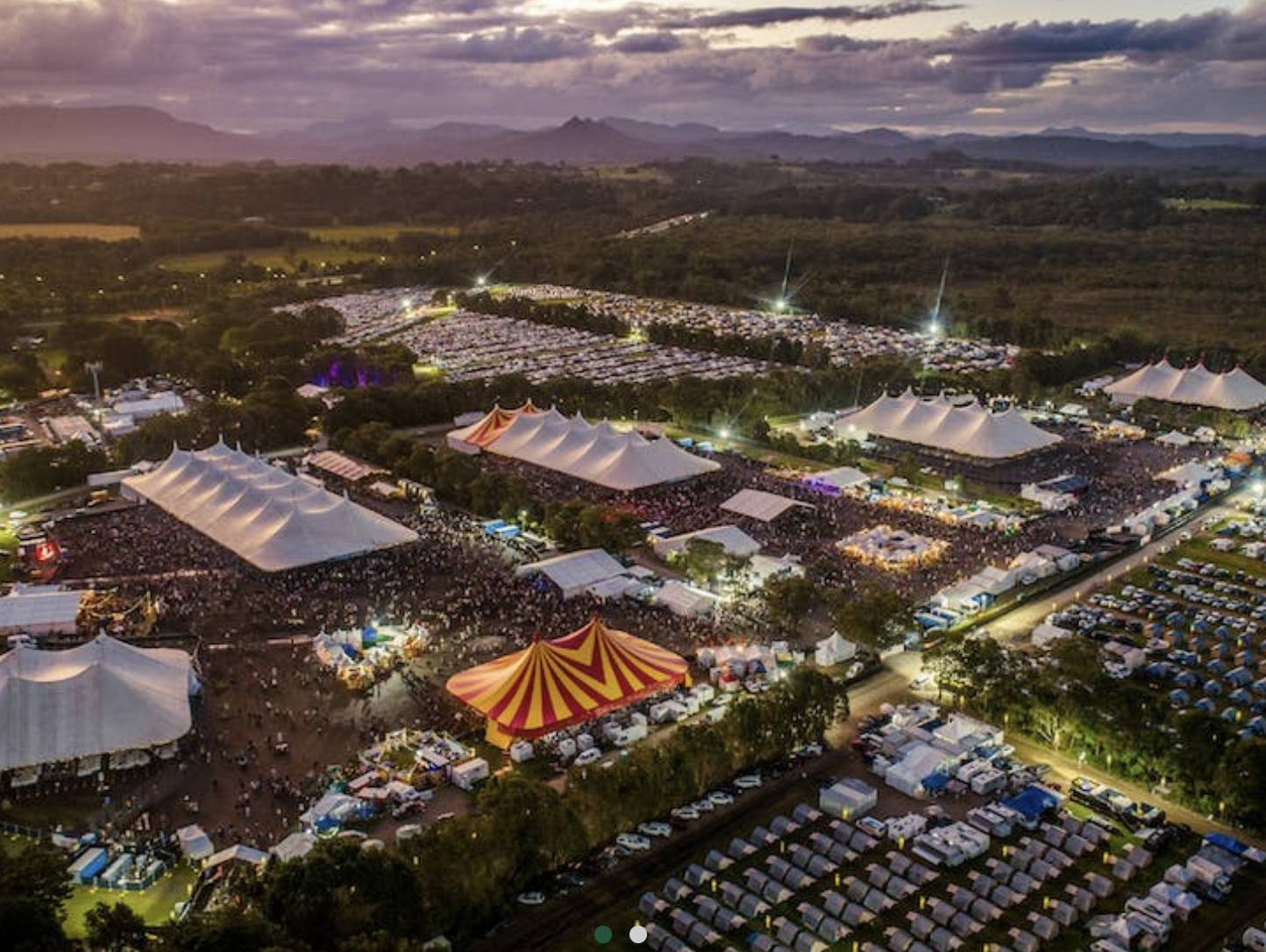 Escenario de música al aire libre en un campo verde.
