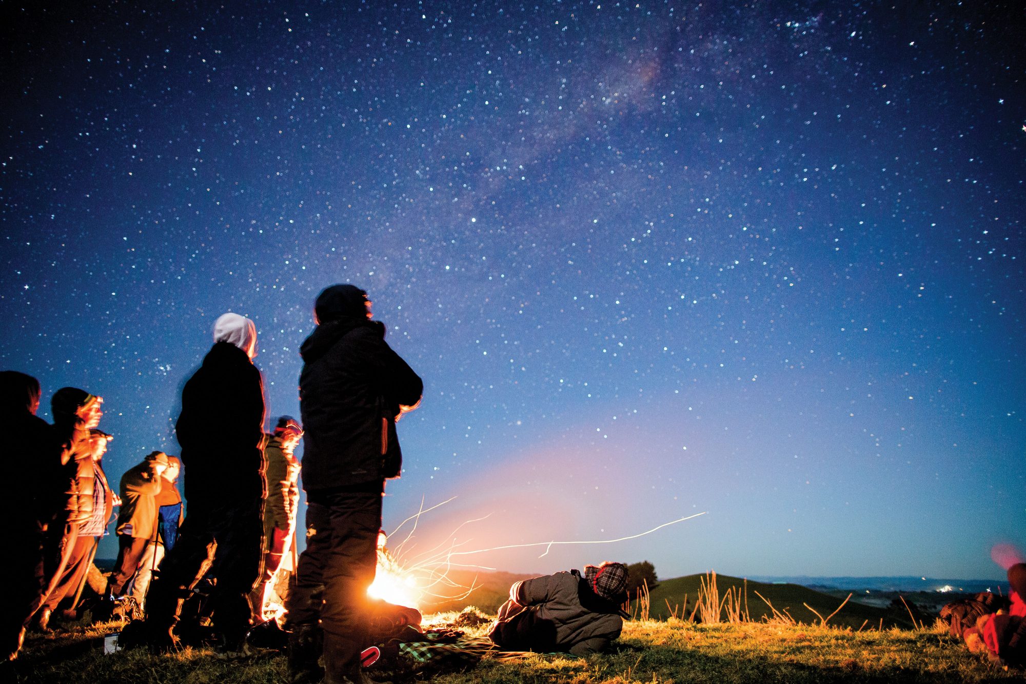Gente mirando las estrellas y faroles maoríes.