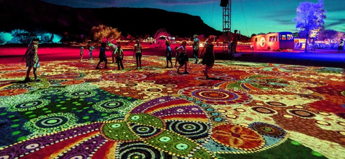 Montañas iluminadas con arte indígena de noche.