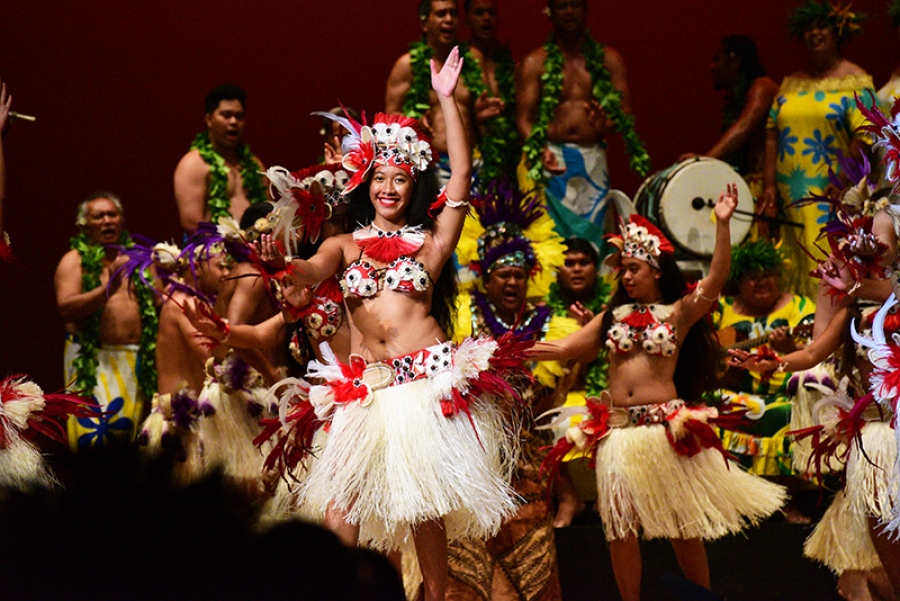 Danzantes con collares de flores en la playa.