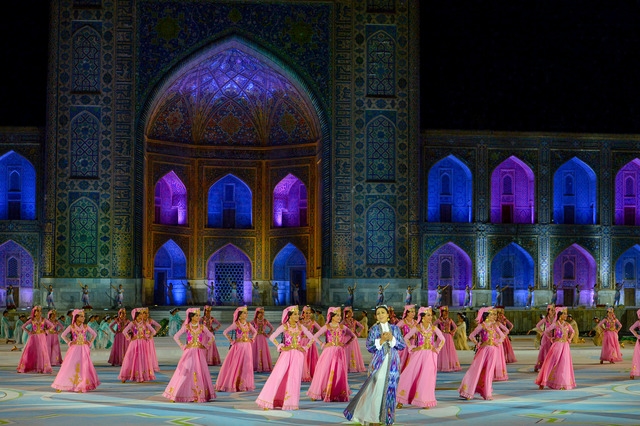 Plaza del Registán iluminada con músicos en el escenario.