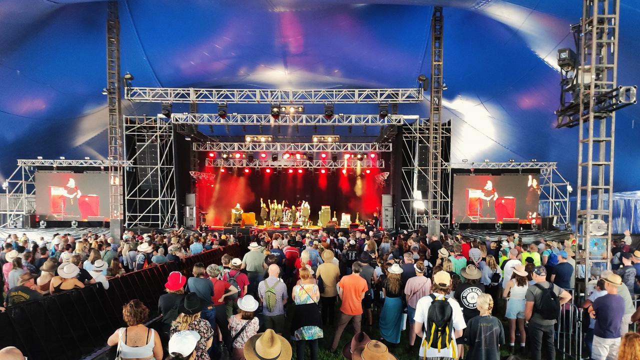 Escenario de música gigante con miles de personas de noche.