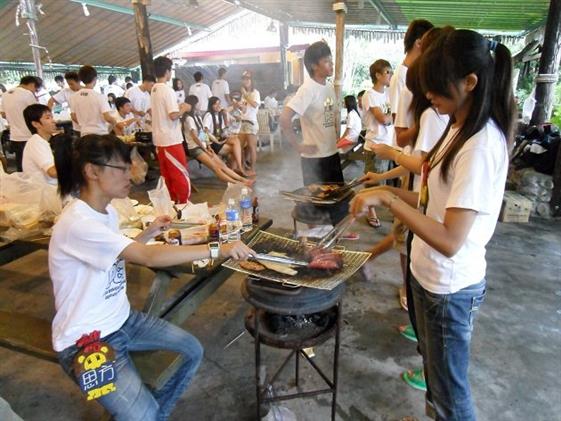 Calles llenas de gente cocinando carne en parrillas portátiles.