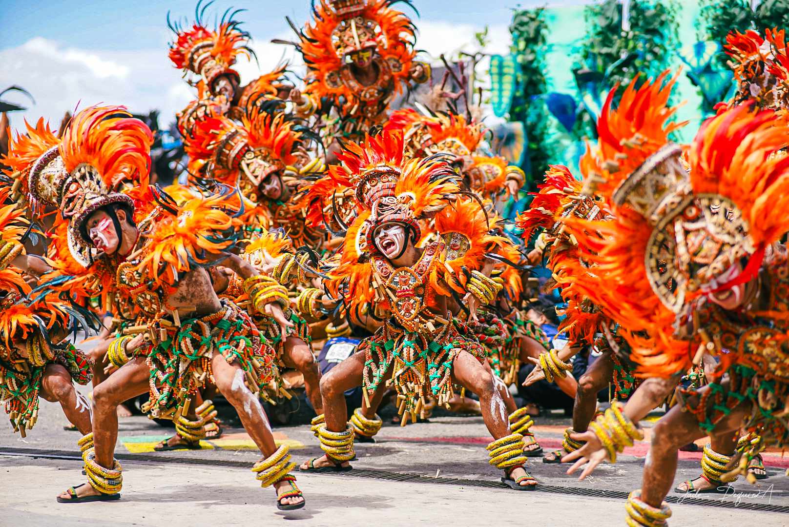 Bailarines saltando al unísono con trajes de guerrero.