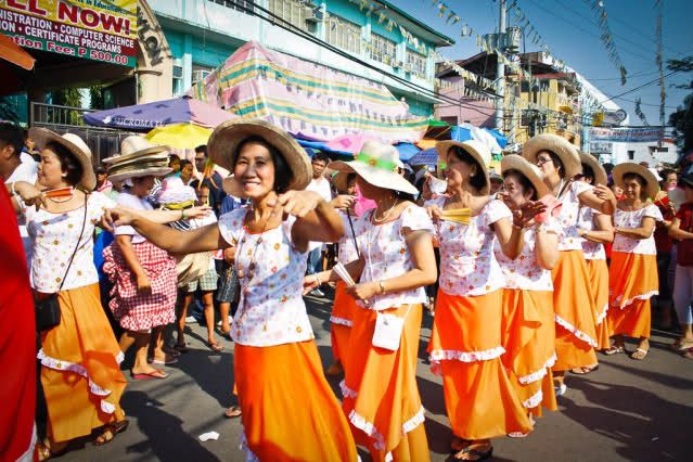Parejas bailando con ropa tradicional frente a la iglesia.
