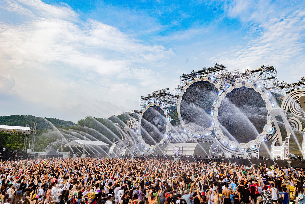Cañones de agua mojando a miles de personas en un concierto.