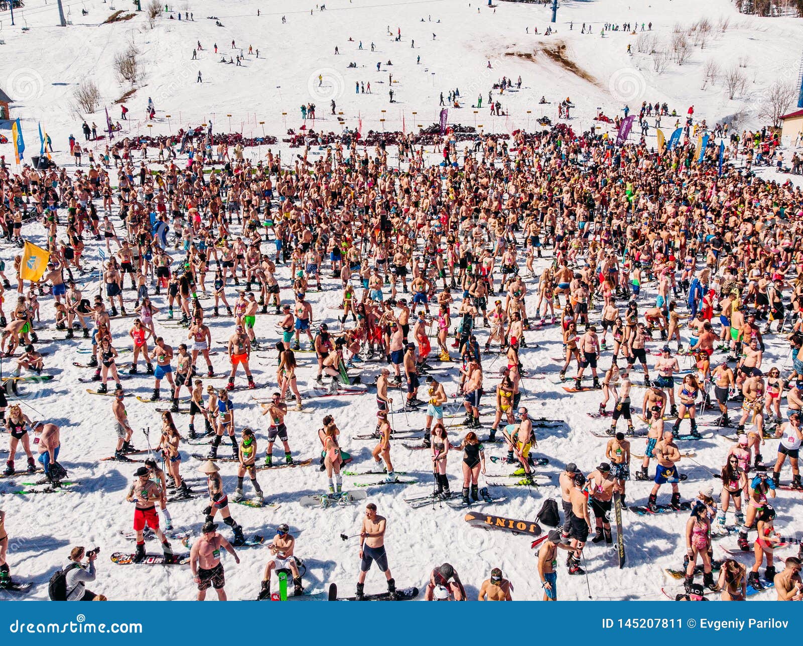 Cientos de personas en bikini esquiando sobre nieve.