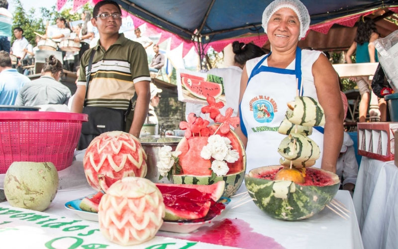 Carroza con forma de sandía gigante y gente manchada.