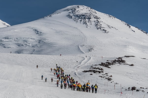 Corredores con crampones en una pendiente de nieve eterna.
