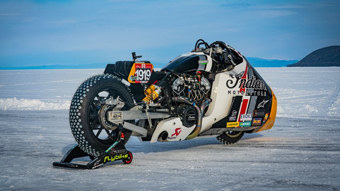 Moto derrapando sobre hielo azul con clavos en las ruedas.