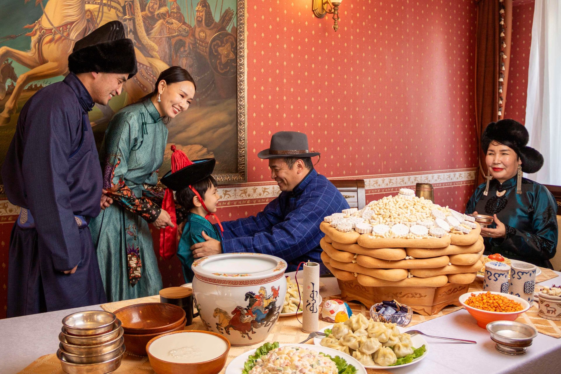 Familia mongola con trajes de seda comiendo buuz.