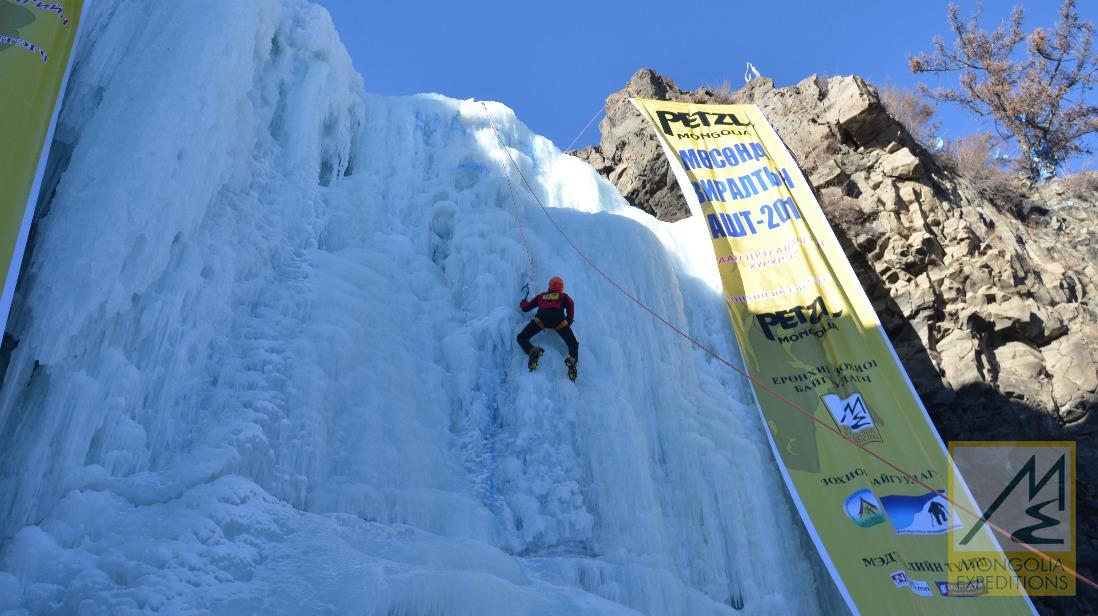 Escalador en una pared de hielo azul gigante.