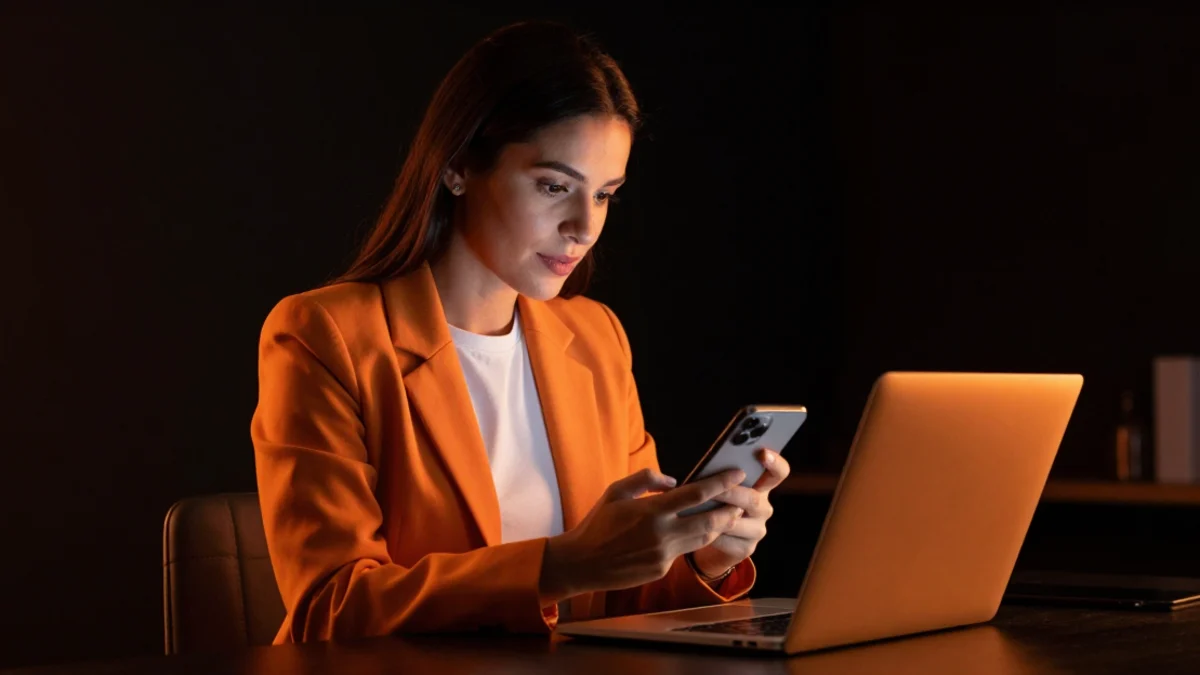 Profissional comparando o recebimento de e-mails no computador e no celular