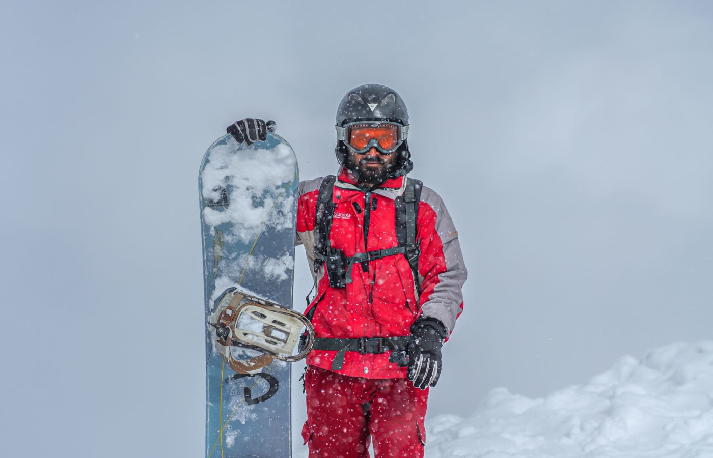Snowboarder in red ski gear standing in fresh snow