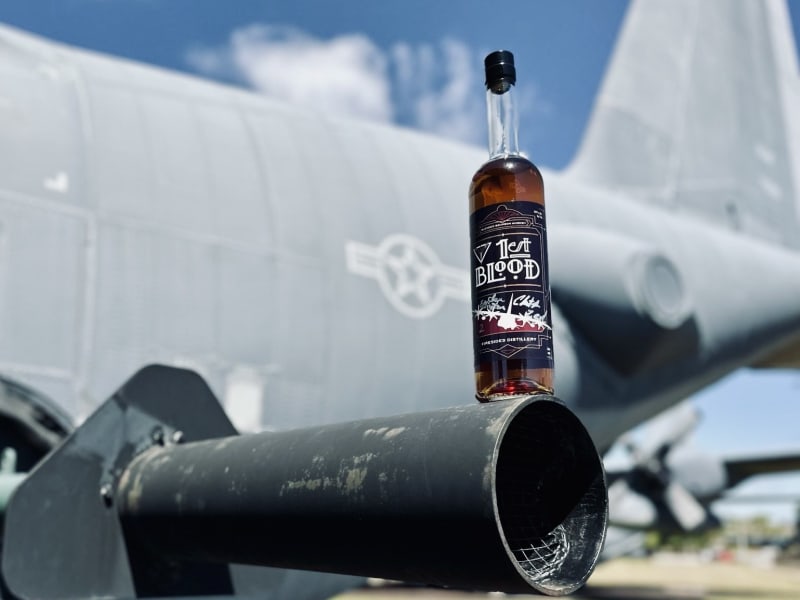 A bottle of 1st Blood perched on the barrel of a gunship cannon.