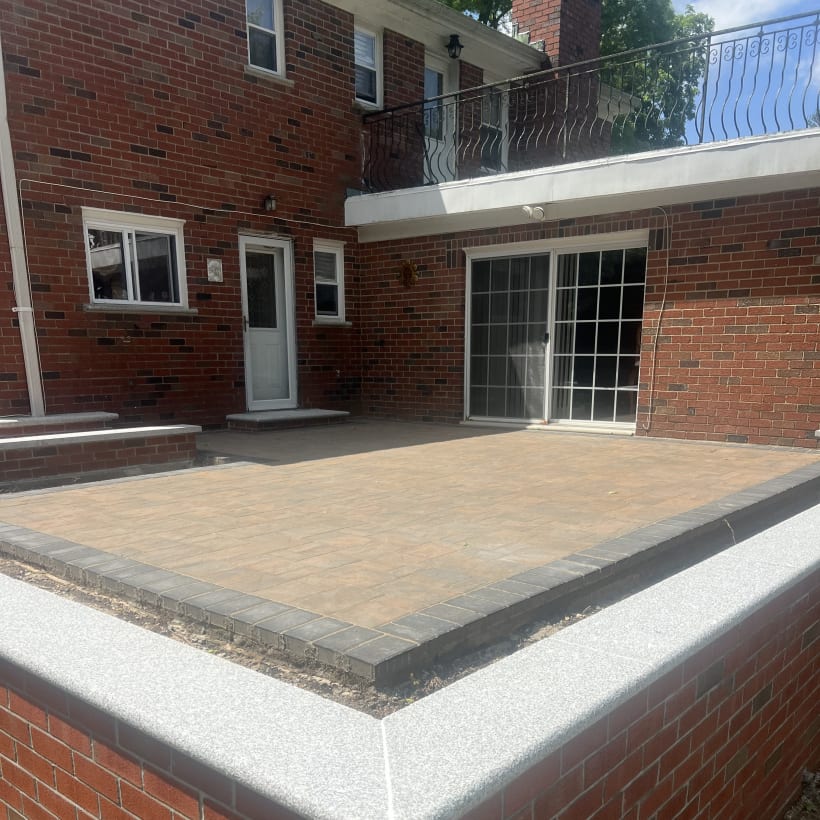 Raised paver patio with brick knee wall and stone coping